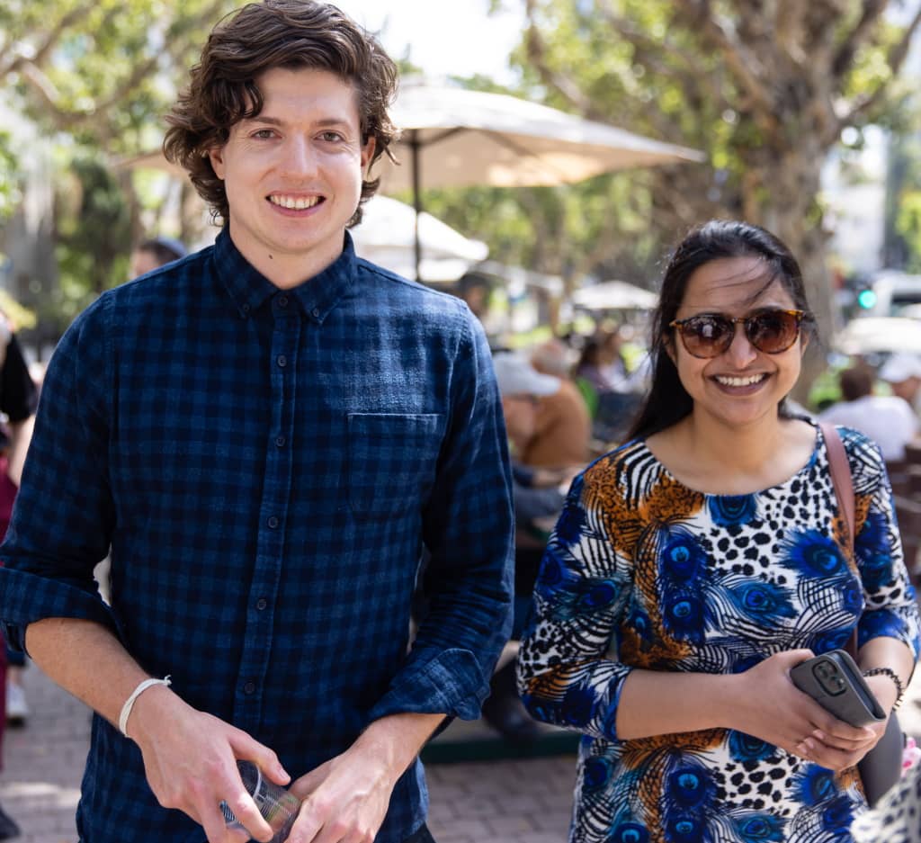 A male and female postdoc smiling on a street in Tel Aviv